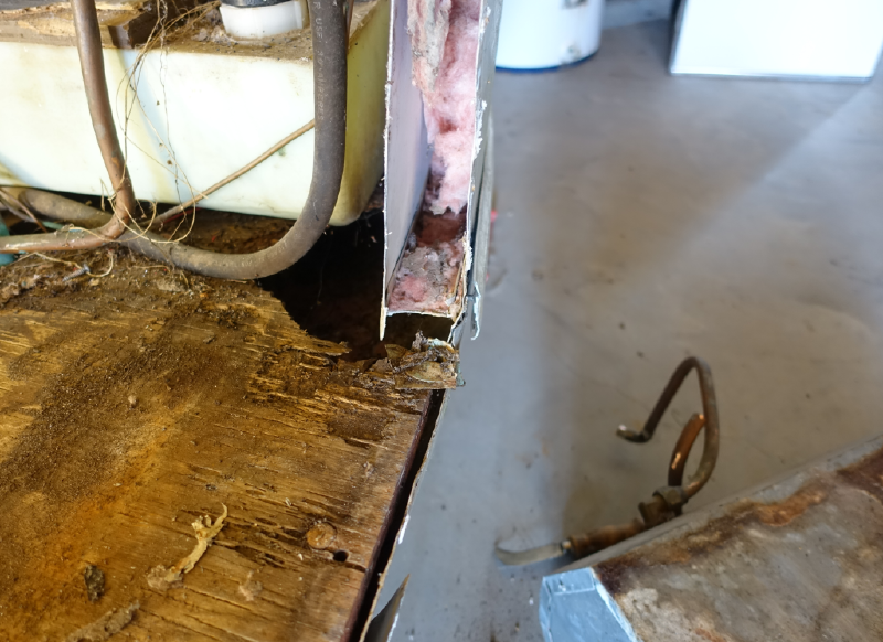 Water heater out — the floor beneath isn&rsquo;t rotten, it&rsquo;s simply gone.